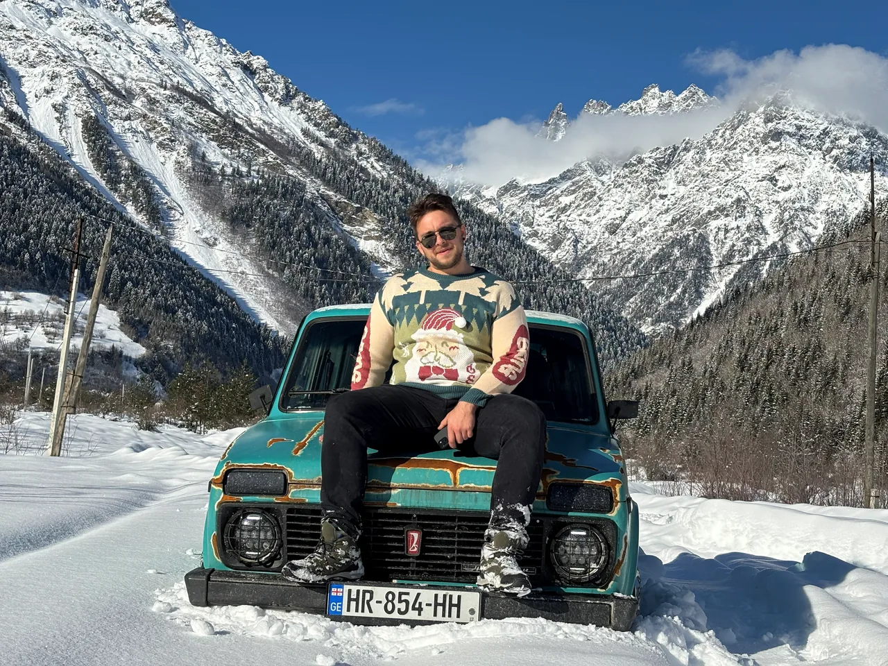 Philipp Gross Kochnov on the hood of his Lada Niva 'Shamil' offroad build, snowy Caucasus